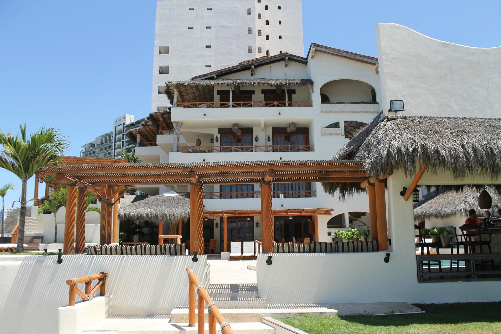 Hotel Playa Fiesta from the beach with palapa roofs and balconies