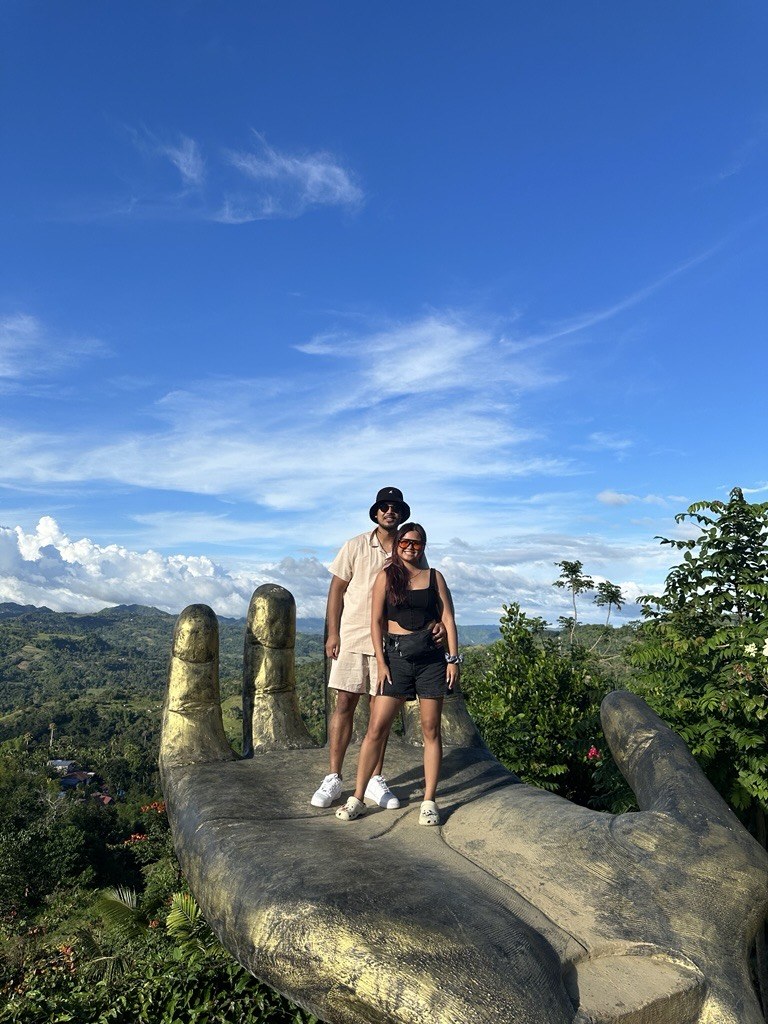 Philip and Kaitlin on the giant hand sculpture overlooking the mountains