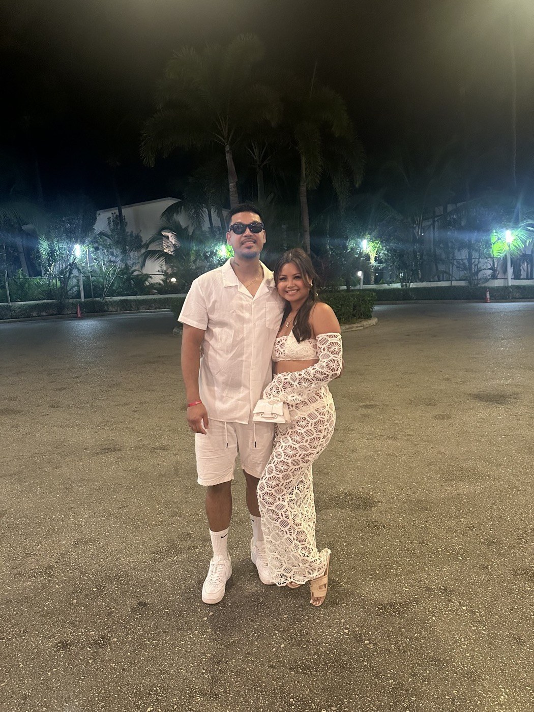Philip and Kaitlin in all-white outfits on a tropical night